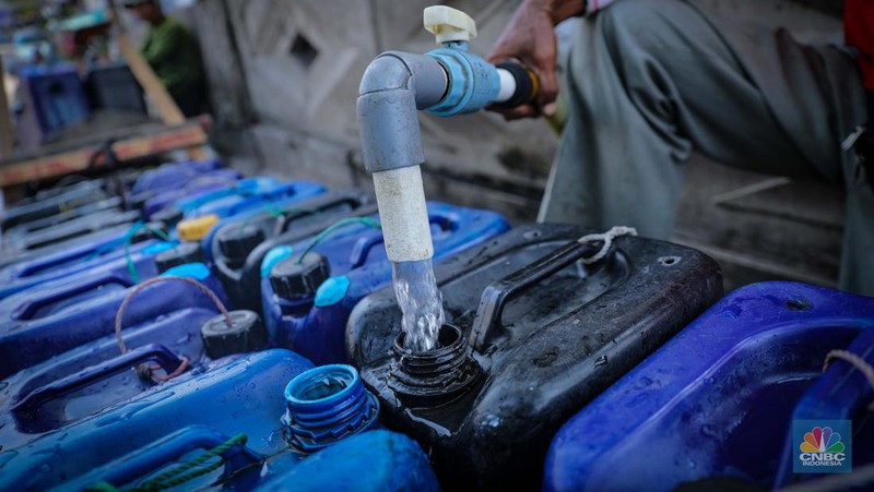 Pekerja mengisi air bersih ke dalam jerigen untuk dijual di kawasan Muara Angke, Jakarta Utara, Senin (30/8/2023). (CNBC Indonesia/Faisal Rahman)