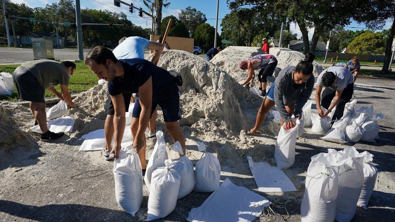 Seorang pria meletakkan kayu lapis di depan sebuah toko menjelang datangnya Badai Idalia di Cedar Key, Florida, AS, 29 Agustus 2023. (REUTERS/Marco Bello)