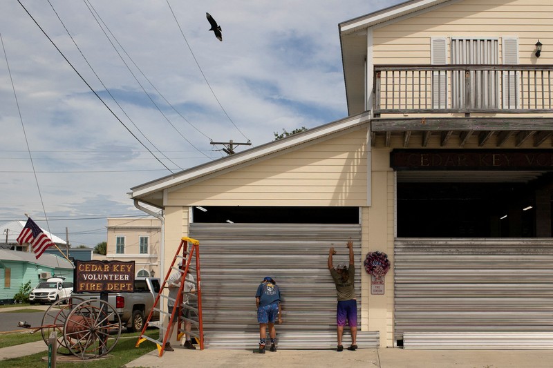 Seorang pria meletakkan kayu lapis di depan sebuah toko menjelang datangnya Badai Idalia di Cedar Key, Florida, AS, 29 Agustus 2023. Seorang pria meletakkan kayu lapis di depan sebuah toko menjelang datangnya Badai Idalia di Cedar Key, Florida, AS, 29 Agustus 2023. (REUTERS/Marco Bello)