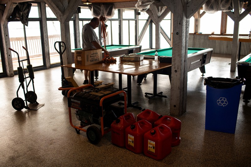 Seorang pria meletakkan kayu lapis di depan sebuah toko menjelang datangnya Badai Idalia di Cedar Key, Florida, AS, 29 Agustus 2023. (REUTERS/Marco Bello)
