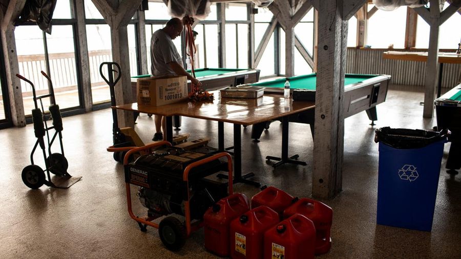 Seorang pria meletakkan kayu lapis di depan sebuah toko menjelang datangnya Badai Idalia di Cedar Key, Florida, AS, 29 Agustus 2023. (REUTERS/Marco Bello)