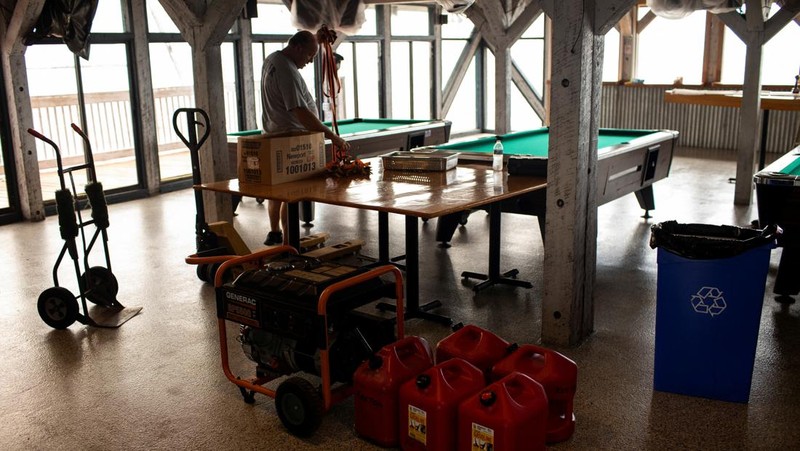 Seorang pria meletakkan kayu lapis di depan sebuah toko menjelang datangnya Badai Idalia di Cedar Key, Florida, AS, 29 Agustus 2023. (REUTERS/Marco Bello)