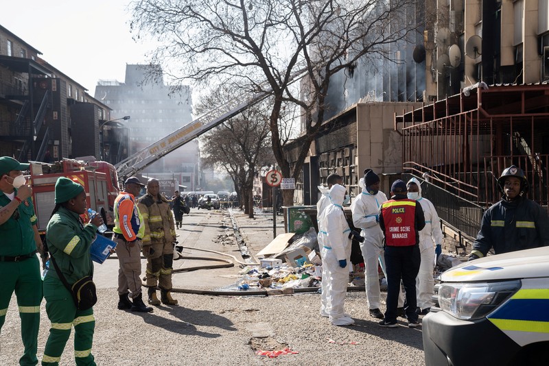 Petugas medis dan darurat bekerja di lokasi kebakaran mematikan di pusat kota Johannesburg Kamis, 31 Agustus 2023. Puluhan orang tewas ketika kebakaran melanda gedung bertingkat di Johannesburg, kota terbesar di Afrika Selatan, kata layanan darurat Kamis. (AP Photo/Jerome Delay)