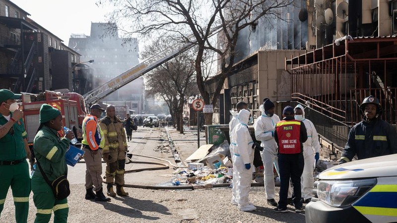 Petugas medis dan darurat bekerja di lokasi kebakaran mematikan di pusat kota Johannesburg Kamis, 31 Agustus 2023. Puluhan orang tewas ketika kebakaran melanda gedung bertingkat di Johannesburg, kota terbesar di Afrika Selatan, kata layanan darurat Kamis. (AP Photo/Jerome Delay)