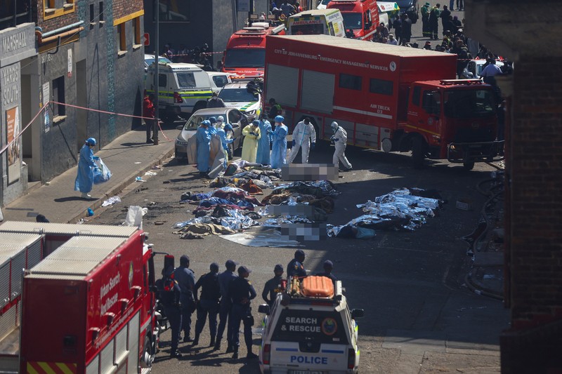 Petugas medis dan darurat bekerja di lokasi kebakaran mematikan di pusat kota Johannesburg Kamis, 31 Agustus 2023. Puluhan orang tewas ketika kebakaran melanda gedung bertingkat di Johannesburg, kota terbesar di Afrika Selatan, kata layanan darurat Kamis. (AP Photo/Jerome Delay)
