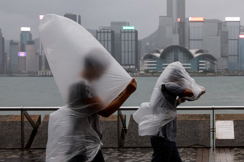 Masyarakat menghadapi angin kencang saat Topan Super Saola mendekat, di Hong Kong, Tiongkok 1 September 2023. (REUTERS/Tyrone Siu)