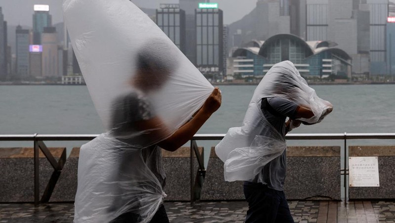 Masyarakat menghadapi angin kencang saat Topan Super Saola mendekat, di Hong Kong, Tiongkok 1 September 2023. (REUTERS/Tyrone Siu)