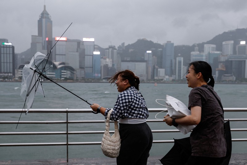 Masyarakat menghadapi angin kencang saat Topan Super Saola mendekat, di Hong Kong, Tiongkok 1 September 2023. (REUTERS/Tyrone Siu)