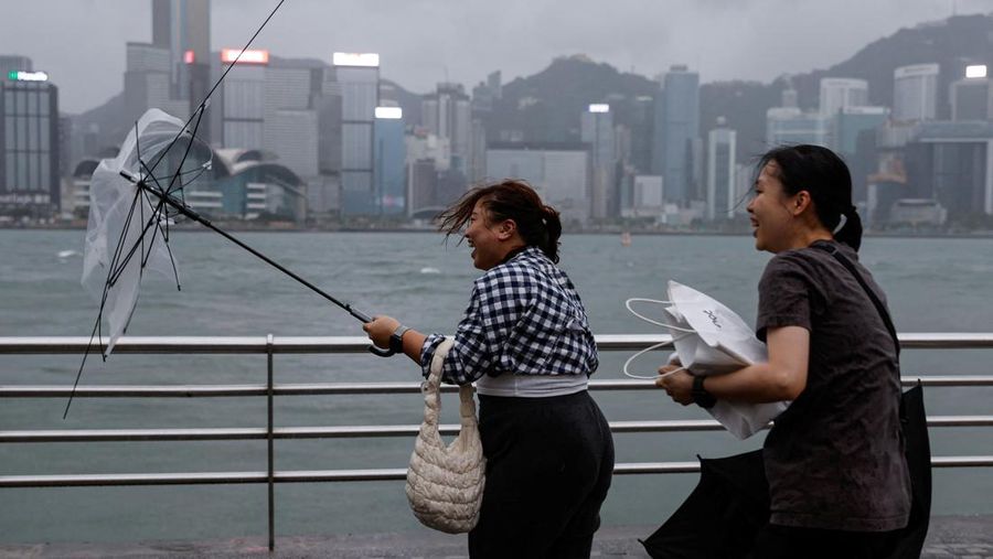 Masyarakat menghadapi angin kencang saat Topan Super Saola mendekat, di Hong Kong, Tiongkok 1 September 2023. (REUTERS/Tyrone Siu)