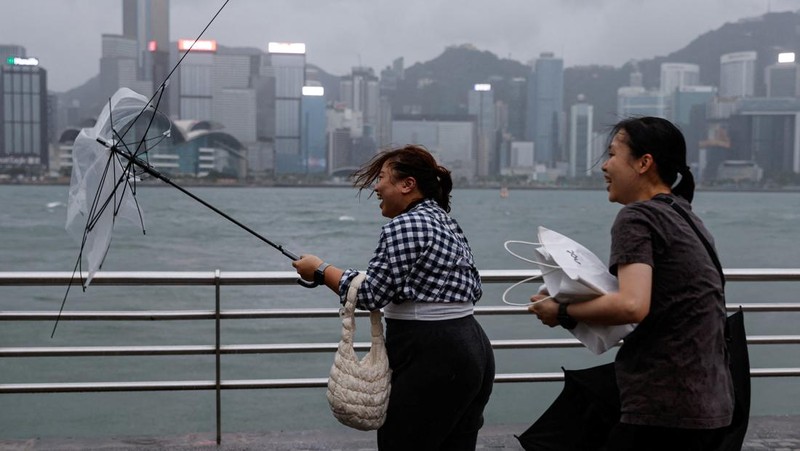 Masyarakat menghadapi angin kencang saat Topan Super Saola mendekat, di Hong Kong, Tiongkok 1 September 2023. (REUTERS/Tyrone Siu)