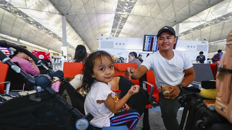 Masyarakat menghadapi angin kencang saat Topan Super Saola mendekat, di Hong Kong, Tiongkok 1 September 2023. (REUTERS/Tyrone Siu)