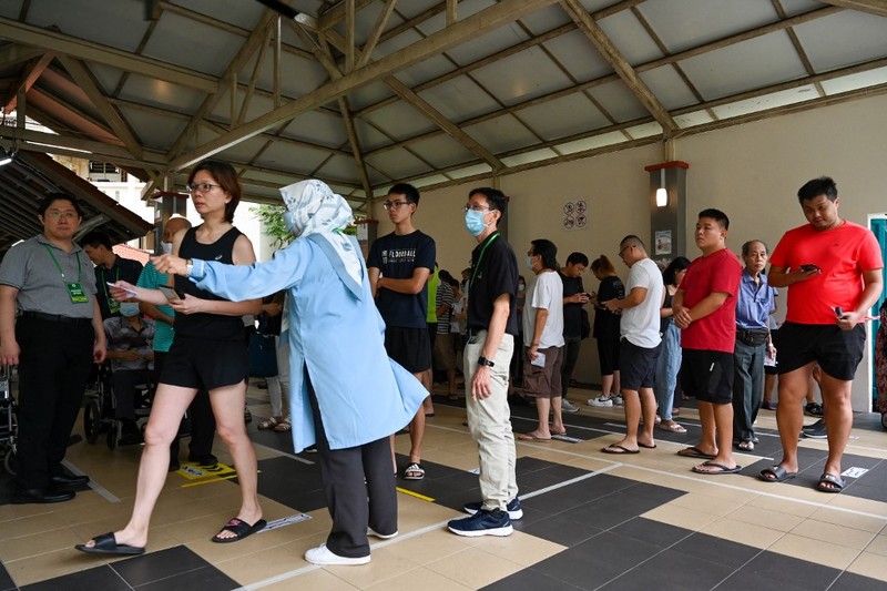 Warga Singapura tiba untuk memberikan suara di tempat pemungutan suara saat pemilihan presiden negara kota tersebut di Singapura pada tanggal 1 September 2023. Warga Singapura akan pergi ke tempat pemungutan suara pada tanggal 1 September dalam pemilihan presiden pertama di negara kota tersebut dalam lebih dari satu dekade, dan pemungutan suara diawasi dengan ketat sebagai indikasi dukungan terhadap partai yang berkuasa setelah serangkaian skandal politik yang jarang terjadi. (Photo by Roslan RAHMAN / AFP)