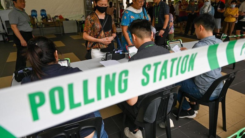 Warga Singapura tiba untuk memberikan suara di tempat pemungutan suara saat pemilihan presiden negara kota tersebut di Singapura pada tanggal 1 September 2023. Warga Singapura akan pergi ke tempat pemungutan suara pada tanggal 1 September dalam pemilihan presiden pertama di negara kota tersebut dalam lebih dari satu dekade, dan pemungutan suara diawasi dengan ketat sebagai indikasi dukungan terhadap partai yang berkuasa setelah serangkaian skandal politik yang jarang terjadi. (Photo by Roslan RAHMAN / AFP)