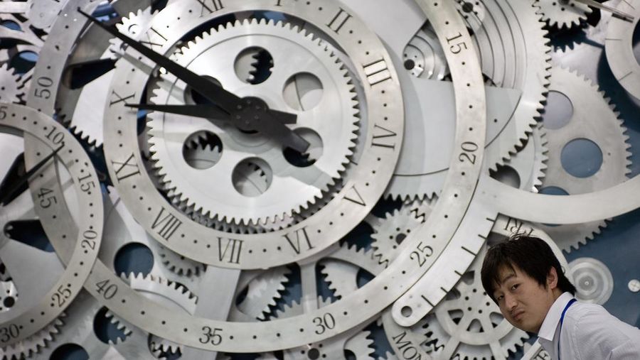 A Chinese man walks past giant wheels of a watch on display at the newly opened China Science and Technology Museum in Beijing, China, Wednesday, Sept. 16, 2009. The new museum was jointly designed by the Beijing Institute of Architectural Design and