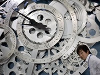 A Chinese man walks past giant wheels of a watch on display at the newly opened China Science and Technology Museum in Beijing, China, Wednesday, Sept. 16, 2009. The new museum was jointly designed by the Beijing Institute of Architectural Design and