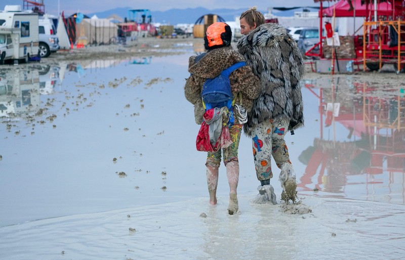 Seorang peserta Burning Man berjalan dengan sepedanya melewati lumpur dekat pintu keluar, setelah hujan badai lebat menyebabkan puluhan ribu orang yang menghadiri festival tahunan terdampar di lumpur di Black Rock City, di gurun Nevada 3 September 2023. Seorang peserta Burning Man berjalan dengan sepedanya melewati lumpur dekat pintu keluar, setelah hujan badai lebat menyebabkan puluhan ribu orang yang menghadiri festival tahunan terdampar di lumpur di Black Rock City, di gurun Nevada 3 September 2023. (Trevor Hughes/USA Today Network via REUTERS)