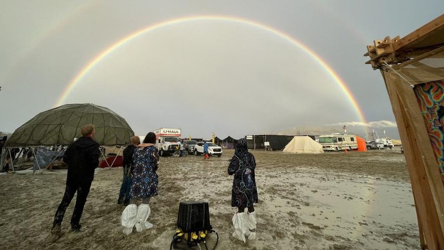 Seorang peserta Burning Man berjalan dengan sepedanya melewati lumpur dekat pintu keluar, setelah hujan badai lebat menyebabkan puluhan ribu orang yang menghadiri festival tahunan terdampar di lumpur di Black Rock City, di gurun Nevada 3 September 2023. (Trevor Hughes/USA Today Network via REUTERS)