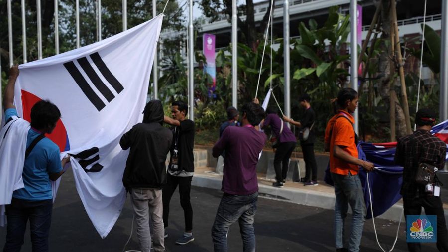 Pekerja menyelesaikan pemasangan bendera negara-negara ASEAN dan mitranya yakini China, Korea Selatan, Amerika Serikat, Jepang dan lainya di Jakarta Convention Center (JCC), Jakarta, Senin (4/9/2023). (CNBC Indonesia/Tri Susilo)