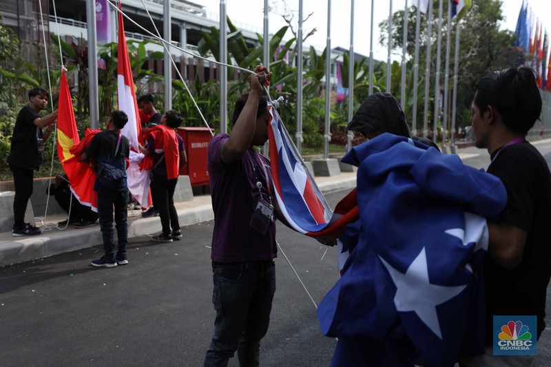 Pekerja menyelesaikan pemasangan bendera negara-negara ASEAN dan mitranya yakini China, Korea Selatan, Amerika Serikat, Jepang dan lainya di Jakarta Convention Center (JCC), Jakarta, Senin (4/9/2023). (CNBC Indonesia/Tri Susilo)