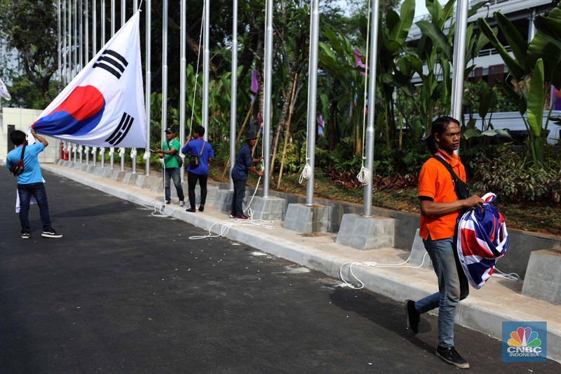 Pekerja menyelesaikan pemasangan bendera negara-negara ASEAN dan mitranya yakini China, Korea Selatan, Amerika Serikat, Jepang dan lainya di Jakarta Convention Center (JCC), Jakarta, Senin (4/9/2023). (CNBC Indonesia/Tri Susilo)