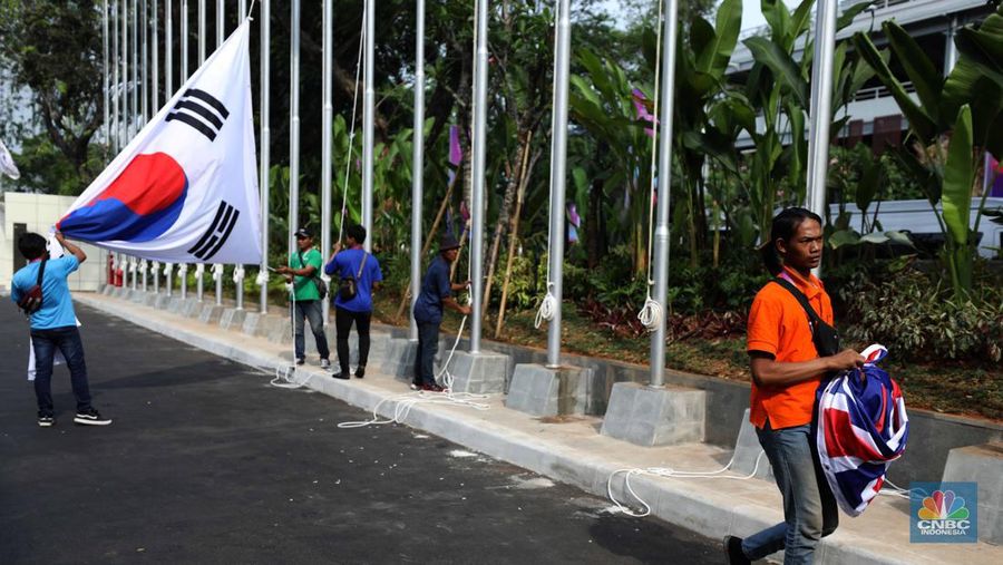 Pekerja menyelesaikan pemasangan bendera negara-negara ASEAN dan mitranya yakini China, Korea Selatan, Amerika Serikat, Jepang dan lainya di Jakarta Convention Center (JCC), Jakarta, Senin (4/9/2023). (CNBC Indonesia/Tri Susilo)