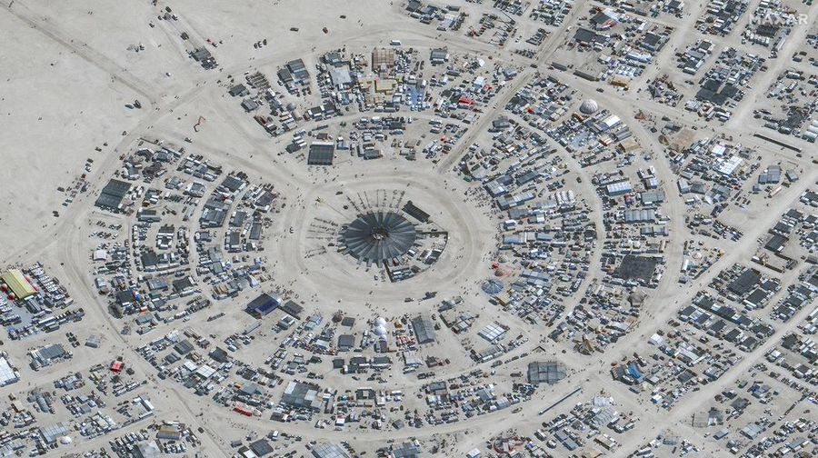 Seorang peserta Burning Man berjalan dengan sepedanya melewati lumpur dekat pintu keluar, setelah hujan badai lebat menyebabkan puluhan ribu orang yang menghadiri festival tahunan terdampar di lumpur di Black Rock City, di gurun Nevada 3 September 2023. (Trevor Hughes/USA Today Network via REUTERS)