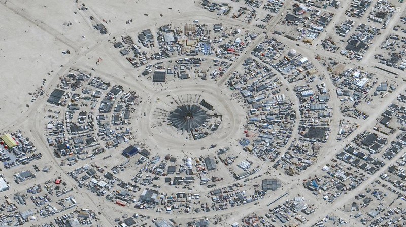 Seorang peserta Burning Man berjalan dengan sepedanya melewati lumpur dekat pintu keluar, setelah hujan badai lebat menyebabkan puluhan ribu orang yang menghadiri festival tahunan terdampar di lumpur di Black Rock City, di gurun Nevada 3 September 2023. (Trevor Hughes/USA Today Network via REUTERS)