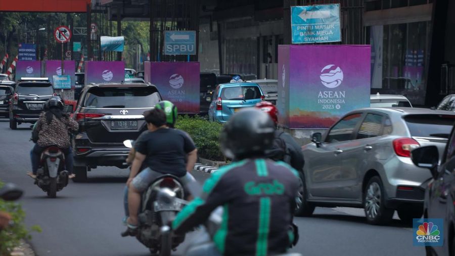 Sejumlah kendaraan melintas di dekat tiang proyek Monorail yang terpasang banner KTT ASEAN 2023 di Jalan Rasuna Said, Jakarta, Senin (4/9/2023). (CNBC Indonesia/Faisal Rahman)
