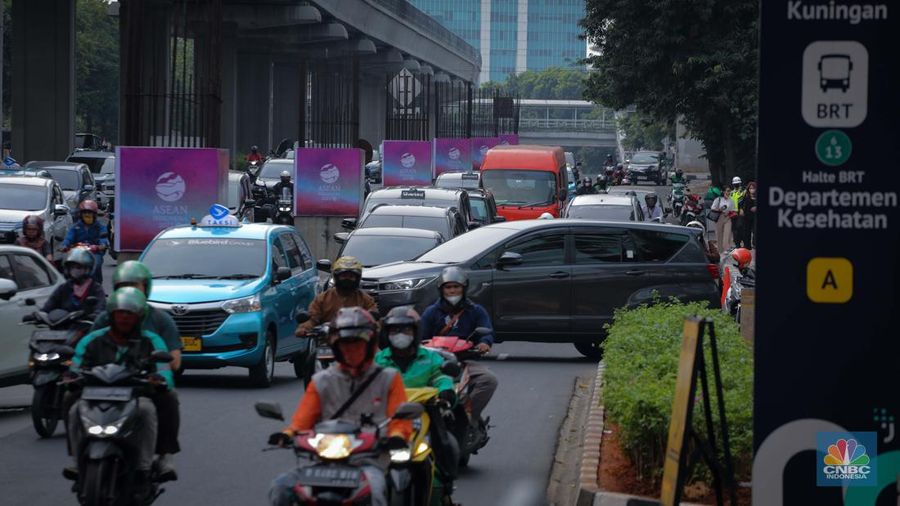 Sejumlah kendaraan melintas di dekat tiang proyek Monorail yang terpasang banner KTT ASEAN 2023 di Jalan Rasuna Said, Jakarta, Senin (4/9/2023). (CNBC Indonesia/Faisal Rahman)