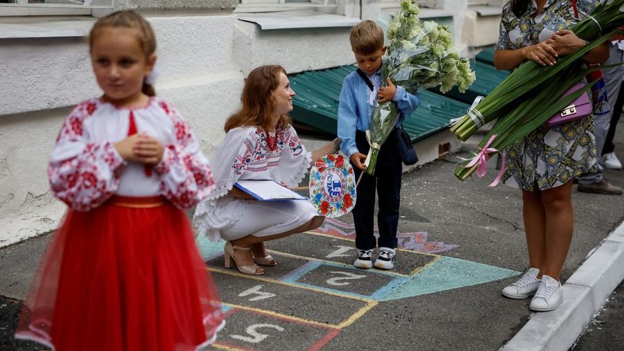 Orang tua bereaksi dan mengucapkan selamat tinggal saat siswa kelas satu mereka meninggalkan upacara untuk menandai dimulainya tahun ajaran baru, di tengah serangan Rusia ke Ukraina, di Kyiv, Ukraina 1 September 2023. (REUTERS/Gleb Garanich)