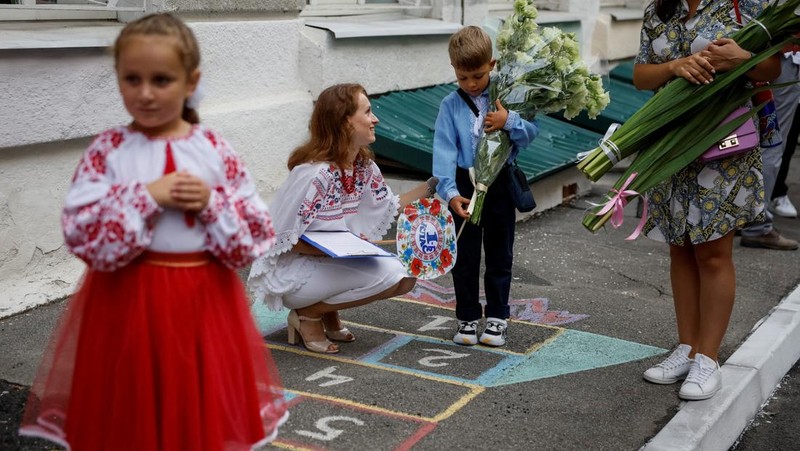 Orang tua bereaksi dan mengucapkan selamat tinggal saat siswa kelas satu mereka meninggalkan upacara untuk menandai dimulainya tahun ajaran baru, di tengah serangan Rusia ke Ukraina, di Kyiv, Ukraina 1 September 2023. (REUTERS/Gleb Garanich)