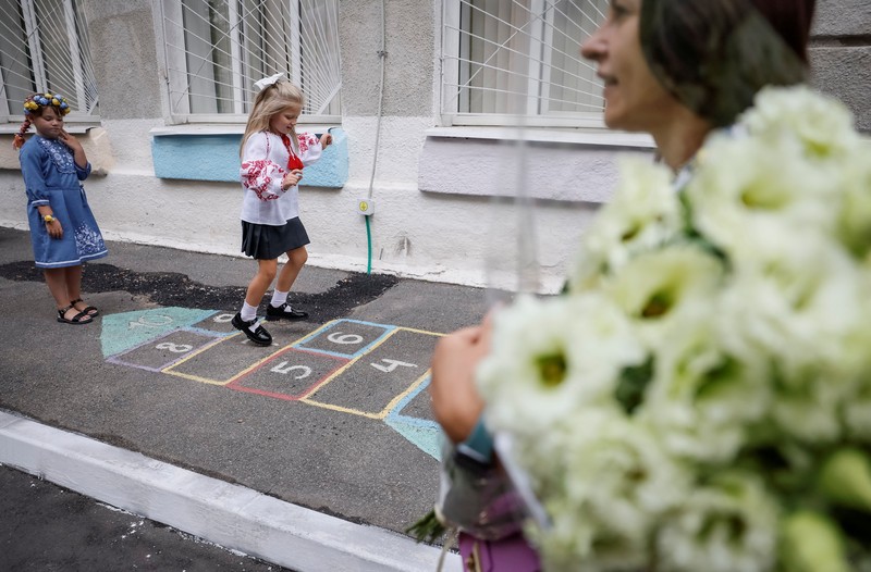 Orang tua bereaksi dan mengucapkan selamat tinggal saat siswa kelas satu mereka meninggalkan upacara untuk menandai dimulainya tahun ajaran baru, di tengah serangan Rusia ke Ukraina, di Kyiv, Ukraina 1 September 2023. (REUTERS/Gleb Garanich)