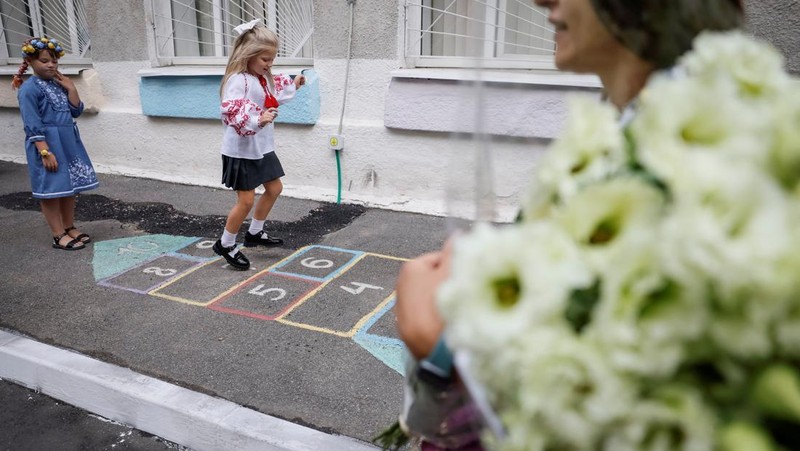 Orang tua bereaksi dan mengucapkan selamat tinggal saat siswa kelas satu mereka meninggalkan upacara untuk menandai dimulainya tahun ajaran baru, di tengah serangan Rusia ke Ukraina, di Kyiv, Ukraina 1 September 2023. (REUTERS/Gleb Garanich)