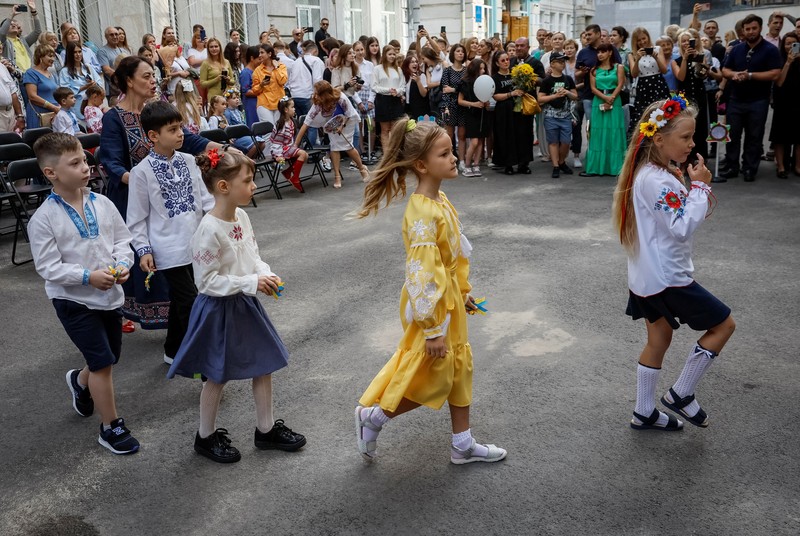 Orang tua bereaksi dan mengucapkan selamat tinggal saat siswa kelas satu mereka meninggalkan upacara untuk menandai dimulainya tahun ajaran baru, di tengah serangan Rusia ke Ukraina, di Kyiv, Ukraina 1 September 2023. (REUTERS/Gleb Garanich)
