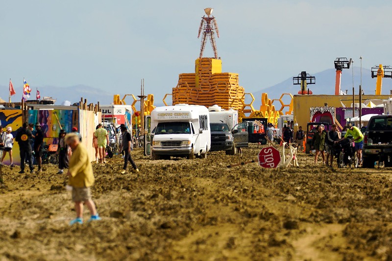 Seorang peserta Burning Man berjalan dengan sepedanya melewati lumpur dekat pintu keluar, setelah hujan badai lebat menyebabkan puluhan ribu orang yang menghadiri festival tahunan terdampar di lumpur di Black Rock City, di gurun Nevada 3 September 2023. Seorang peserta Burning Man berjalan dengan sepedanya melewati lumpur dekat pintu keluar, setelah hujan badai lebat menyebabkan puluhan ribu orang yang menghadiri festival tahunan terdampar di lumpur di Black Rock City, di gurun Nevada 3 September 2023. (Trevor Hughes/USA Today Network via REUTERS)