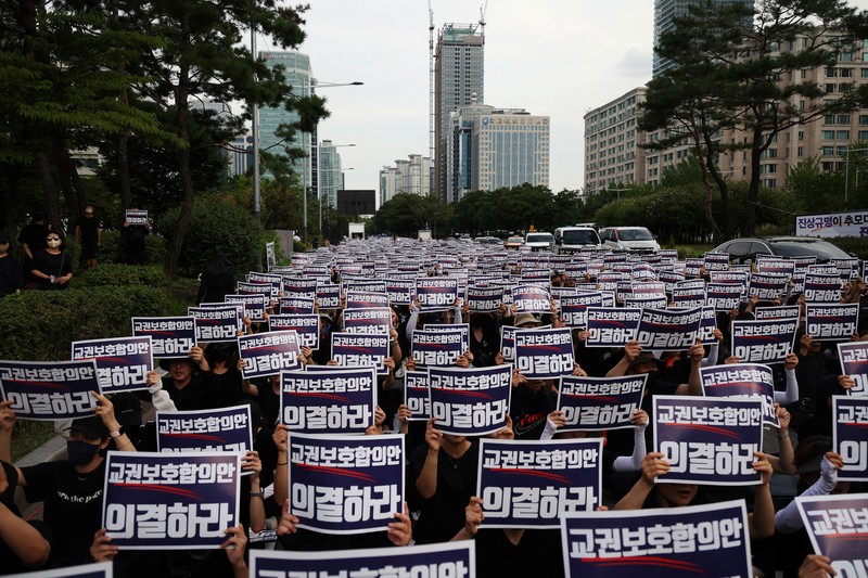 Seorang guru Korea Selatan bereaksi ketika yang lain meneriakkan slogan-slogan selama protes menuntut perlindungan yang lebih baik atas hak-hak mereka, normalisasi pendidikan publik dan berduka atas seorang guru muda yang ditemukan tewas pada bulan Juli karena bunuh diri, di Seoul, Korea Selatan, 4 September 2023. Seorang guru Korea Selatan bereaksi ketika yang lain meneriakkan slogan-slogan selama protes menuntut perlindungan yang lebih baik atas hak-hak mereka, normalisasi pendidikan publik dan berduka atas seorang guru muda yang ditemukan tewas pada bulan Juli karena bunuh diri, di Seoul, Korea Selatan, 4 September 2023 .Tanda-tanda itu bertuliskan