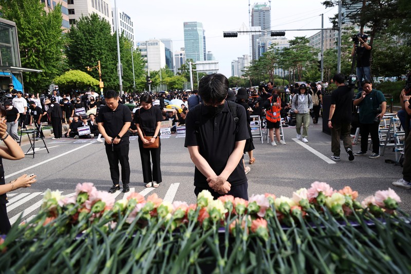 Seorang guru Korea Selatan bereaksi ketika yang lain meneriakkan slogan-slogan selama protes menuntut perlindungan yang lebih baik atas hak-hak mereka, normalisasi pendidikan publik dan berduka atas seorang guru muda yang ditemukan tewas pada bulan Juli karena bunuh diri, di Seoul, Korea Selatan, 4 September 2023 .Tanda-tanda itu bertuliskan 
