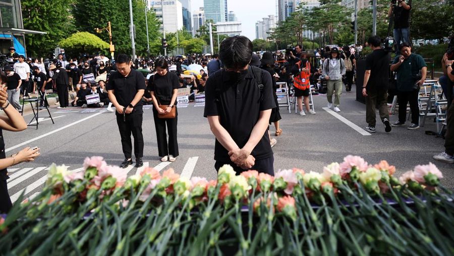 Seorang guru Korea Selatan bereaksi ketika yang lain meneriakkan slogan-slogan selama protes menuntut perlindungan yang lebih baik atas hak-hak mereka, normalisasi pendidikan publik dan berduka atas seorang guru muda yang ditemukan tewas pada bulan Juli karena bunuh diri, di Seoul, Korea Selatan, 4 September 2023 .Tanda-tanda itu bertuliskan 