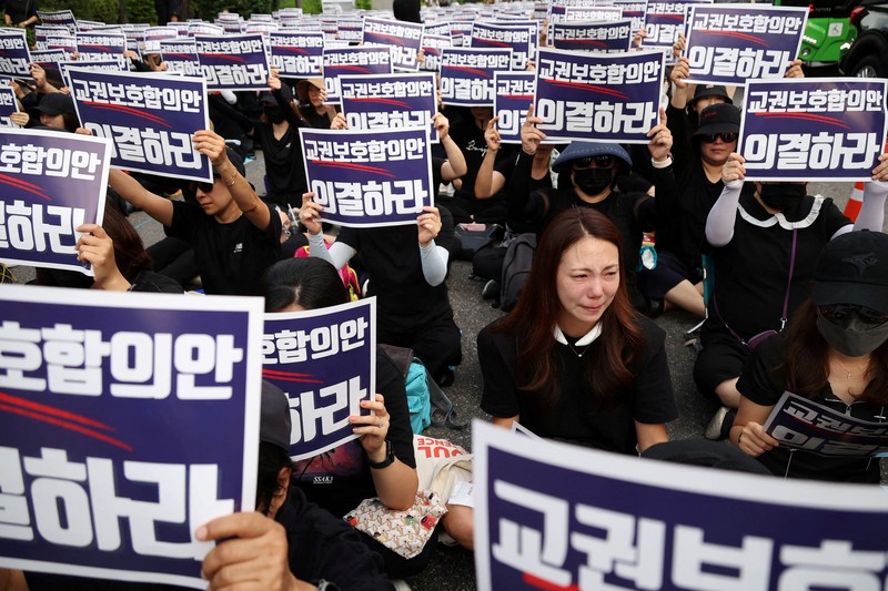 Seorang guru Korea Selatan bereaksi ketika yang lain meneriakkan slogan-slogan selama protes menuntut perlindungan yang lebih baik atas hak-hak mereka, normalisasi pendidikan publik dan berduka atas seorang guru muda yang ditemukan tewas pada bulan Juli karena bunuh diri, di Seoul, Korea Selatan, 4 September 2023. Seorang guru Korea Selatan bereaksi ketika yang lain meneriakkan slogan-slogan selama protes menuntut perlindungan yang lebih baik atas hak-hak mereka, normalisasi pendidikan publik dan berduka atas seorang guru muda yang ditemukan tewas pada bulan Juli karena bunuh diri, di Seoul, Korea Selatan, 4 September 2023 .Tanda-tanda itu bertuliskan