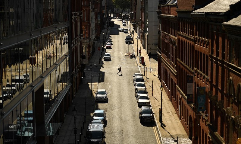 Seorang pejalan kaki melintasi jalan kosong di Birmingham, Inggris tengah pada 14 September 2020. (Photo by Oli SCARFF / AFP/File Foto)