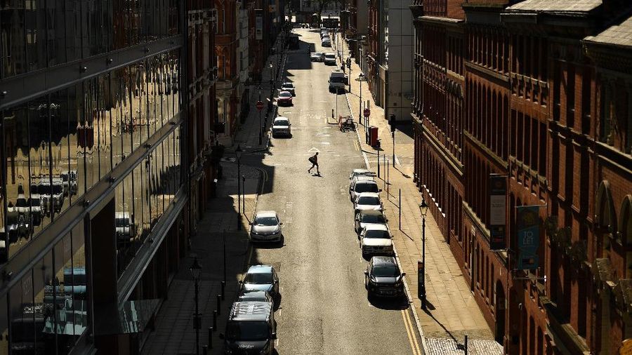 Seorang pejalan kaki melintasi jalan kosong di Birmingham, Inggris tengah pada 14 September 2020. (Photo by Oli SCARFF / AFP/File Foto)