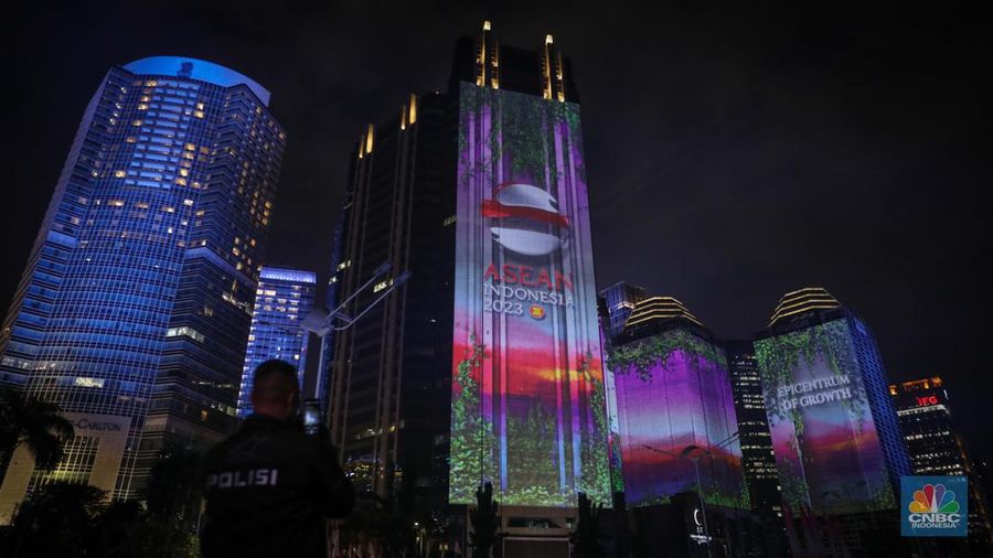 Warga menyaksikan penampilan video mapping dengan tema KTT ASEAN 2023 di Jalan Jendral Sudirman, Jakarta, Rabu (6/9/2023). (CNBC Indonesia/Faisal Rahman)