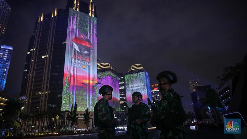 Warga menyaksikan penampilan video mapping dengan tema KTT ASEAN 2023 di Jalan Jendral Sudirman, Jakarta, Rabu (6/9/2023). (CNBC Indonesia/Faisal Rahman)