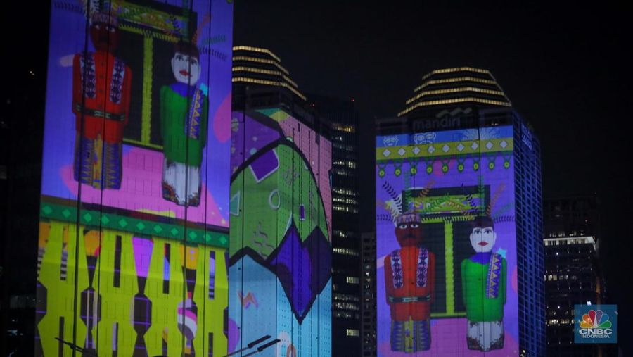 Warga menyaksikan penampilan video mapping dengan tema KTT ASEAN 2023 di Jalan Jendral Sudirman, Jakarta, Rabu (6/9/2023). (CNBC Indonesia/Faisal Rahman)