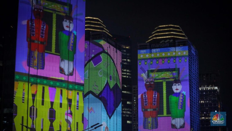 Warga menyaksikan penampilan video mapping dengan tema KTT ASEAN 2023 di Jalan Jendral Sudirman, Jakarta, Rabu (6/9/2023). (CNBC Indonesia/Faisal Rahman)