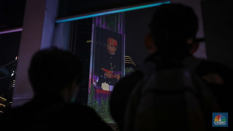Warga menyaksikan penampilan video mapping dengan tema KTT ASEAN 2023 di Jalan Jendral Sudirman, Jakarta, Rabu (6/9/2023). (CNBC Indonesia/Faisal Rahman)