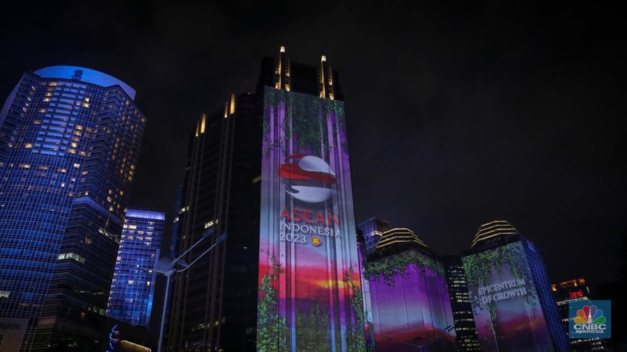 Warga menyaksikan penampilan video mapping dengan tema KTT ASEAN 2023 di Jalan Jendral Sudirman, Jakarta, Rabu (6/9/2023). (CNBC Indonesia/Faisal Rahman)