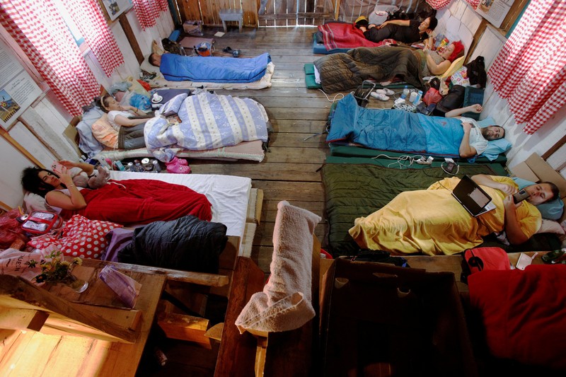 Peserta berbaring di dalam gubuk, saat mengikuti kontes satir untuk mengejek mitos populer yang menyebut orang Montenegro sebagai orang malas, di desa Brezna, Pluzine, Montenegro, 6 September 2023. (REUTERS/Stevo Vasiljevic)