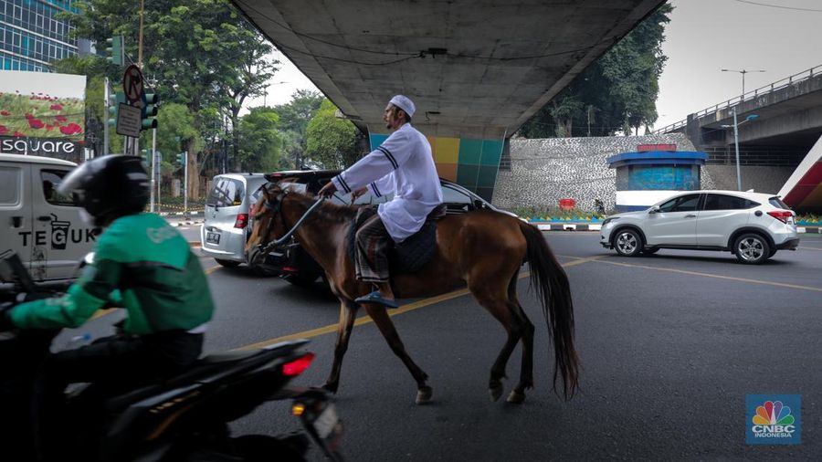 Seorang pria bernama Abdullah nampak menunggangi kuda saat melintas di Jalan Dewi Sartika, Jakarta Timur, Jumat (8/9/2023). (CNBC Indonesia/Faisal Rahman)