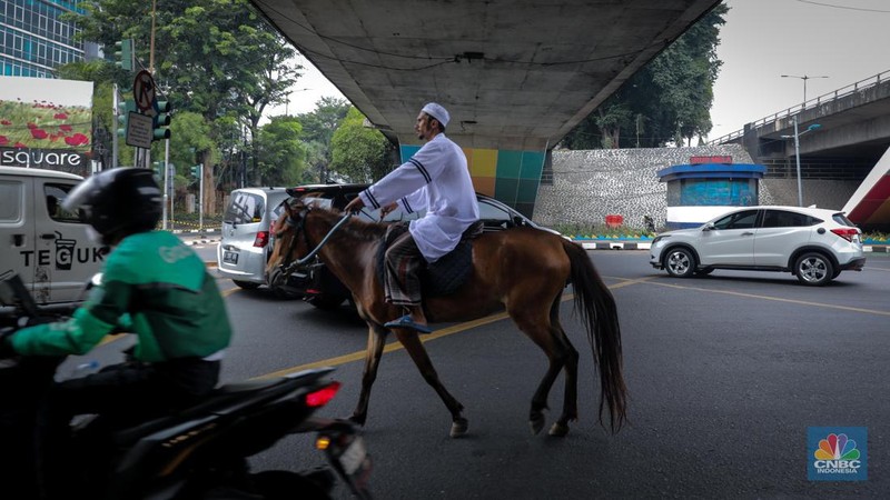 Seorang pria bernama Abdullah nampak menunggangi kuda saat melintas di Jalan Dewi Sartika, Jakarta Timur, Jumat (8/9/2023). (CNBC Indonesia/Faisal Rahman)